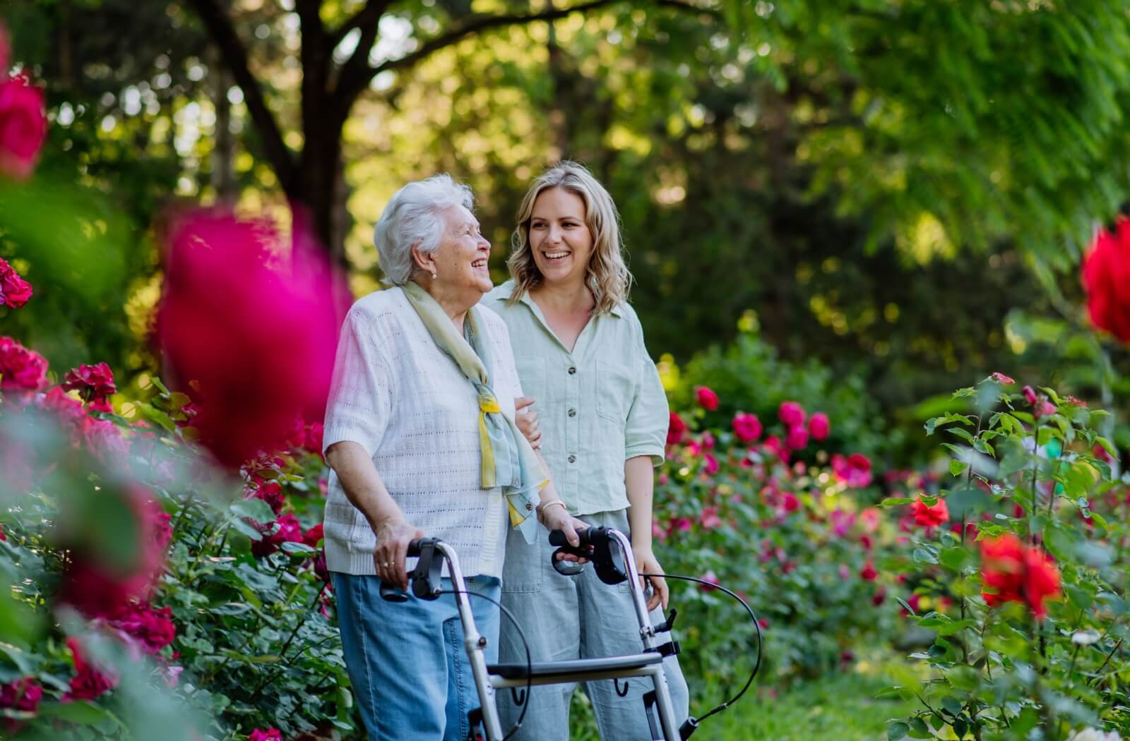 An older adult enjoys the outdoors while using a walker as a mobility aid for extra support.