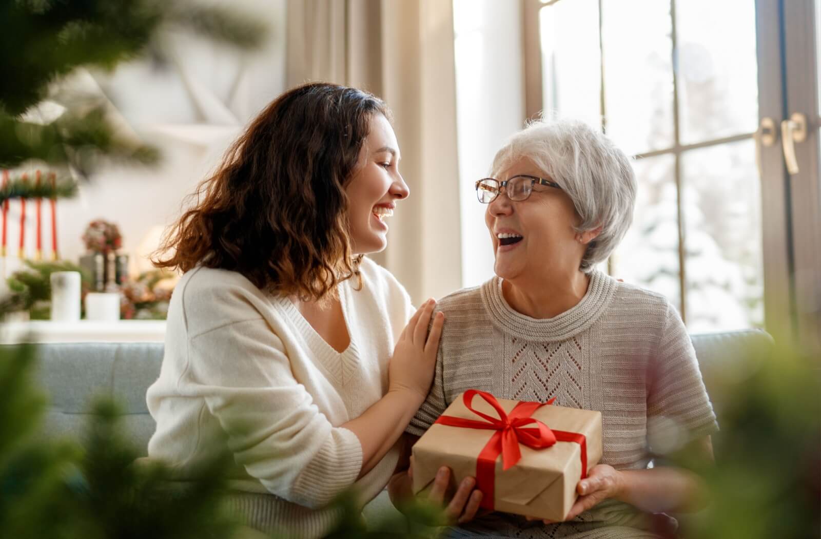 A person giving their senior parent a gift for the holidays