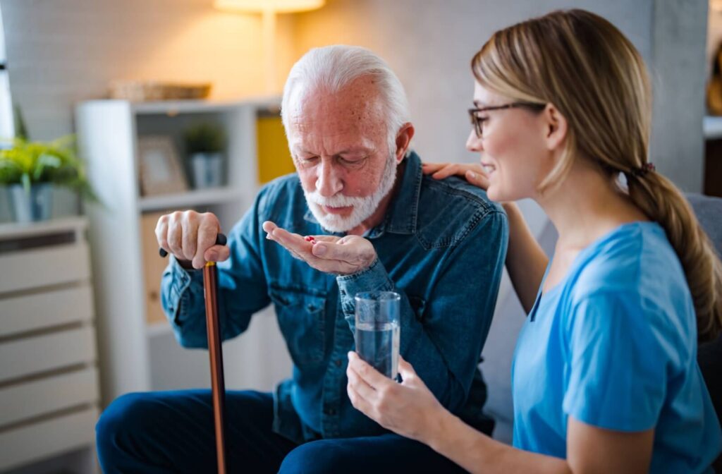 A staff member in assisted living making sure a resident takes their medication.