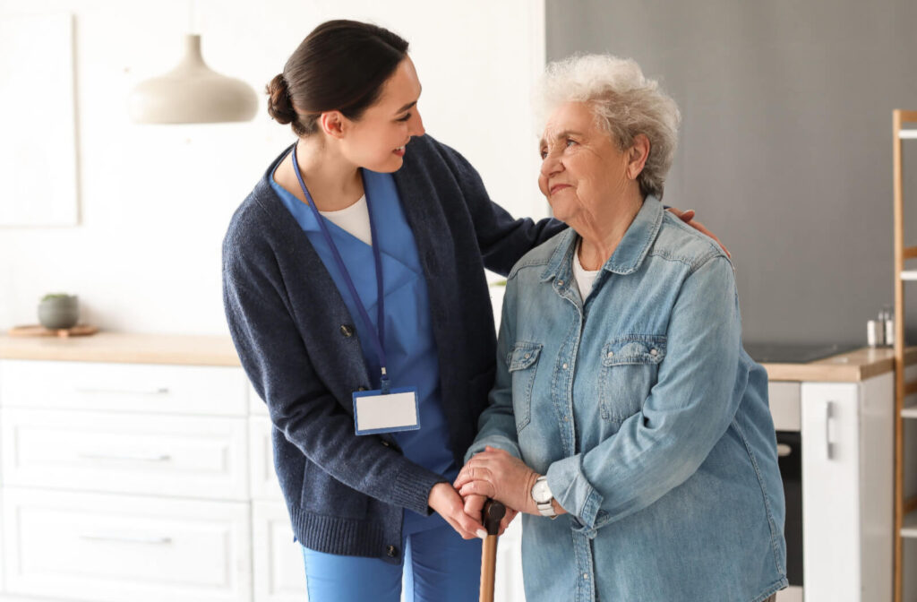 A smiling caregiver checks in on an appreciative resident in assisted living