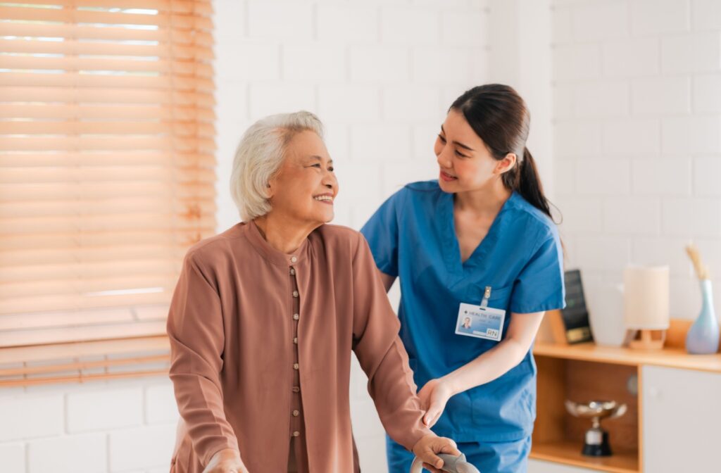 a caregiver helping a senior with walker in senior living community